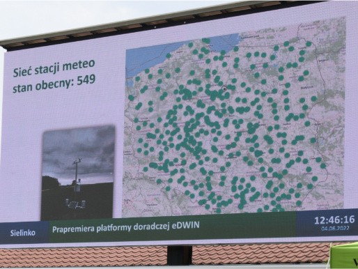 Na zdjęciu widoczny jest telebim, na którym wyświetlona jest mapa Polski z lokalizacją stacji meteorologicznych.